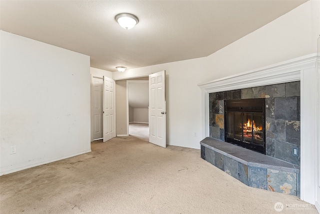 unfurnished living room with carpet, a fireplace, and baseboards