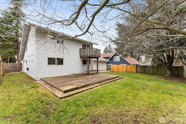 back of house with a fenced backyard, a lawn, a deck, and a balcony