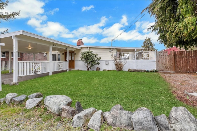 view of yard featuring covered porch and fence