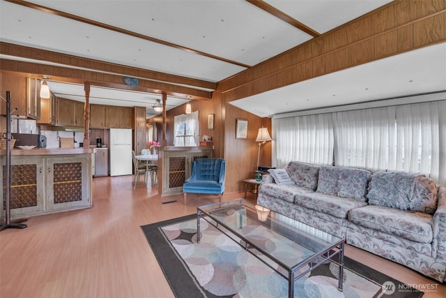 living room with light wood finished floors and wooden walls