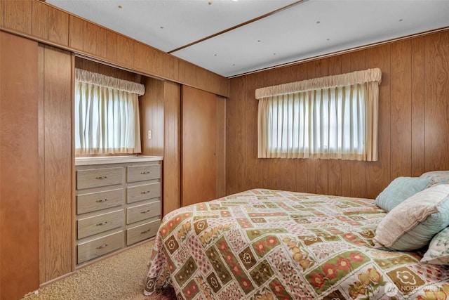 bedroom with carpet floors and wooden walls