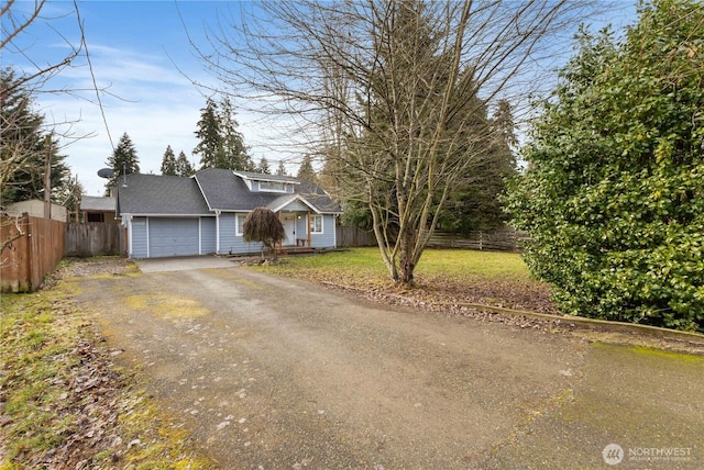 view of front of home with driveway, a garage, fence, and a front yard