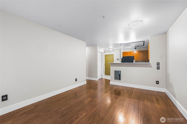 unfurnished living room with track lighting and dark hardwood / wood-style floors