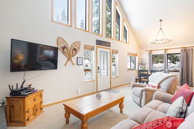 living area featuring high vaulted ceiling, baseboards, a chandelier, and light colored carpet