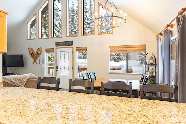 dining room featuring high vaulted ceiling and a notable chandelier