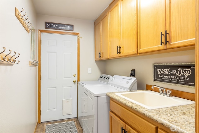 laundry area featuring cabinet space, a sink, and washing machine and clothes dryer