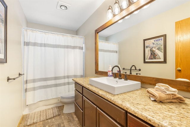 full bathroom featuring toilet, shower / bath combination with curtain, and vanity