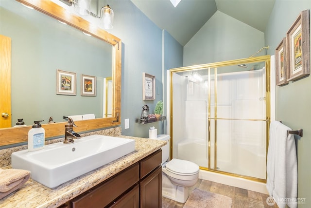 full bathroom featuring a stall shower, toilet, wood finished floors, vaulted ceiling, and vanity