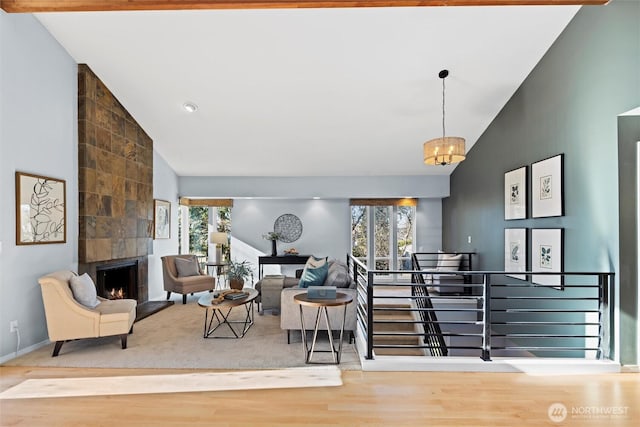 living room with high vaulted ceiling, a large fireplace, an inviting chandelier, and wood-type flooring