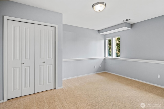 unfurnished bedroom featuring carpet and a closet