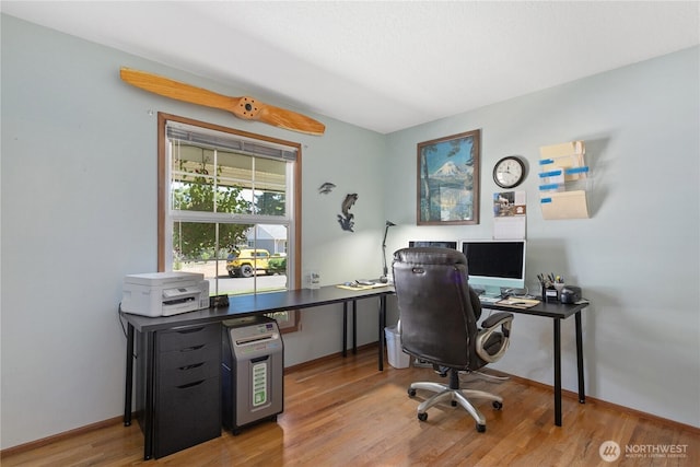 office area featuring baseboards and light wood finished floors