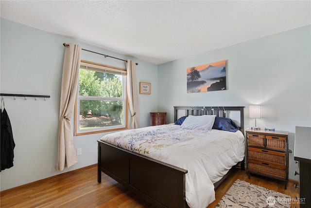 bedroom featuring baseboards and wood finished floors