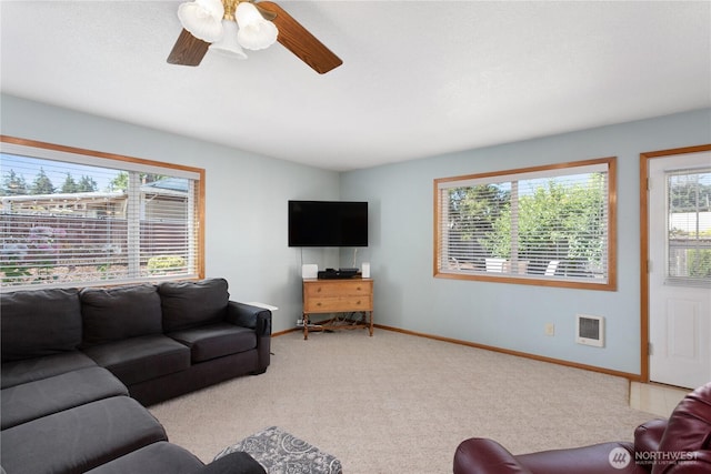 living room with light carpet, heating unit, ceiling fan, and baseboards