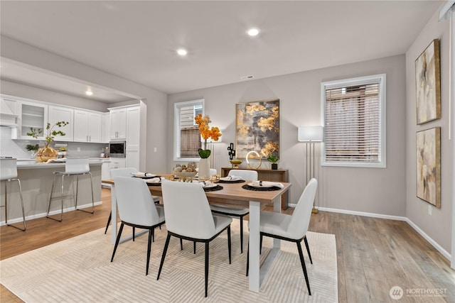 dining room featuring baseboards, light wood-type flooring, visible vents, and recessed lighting