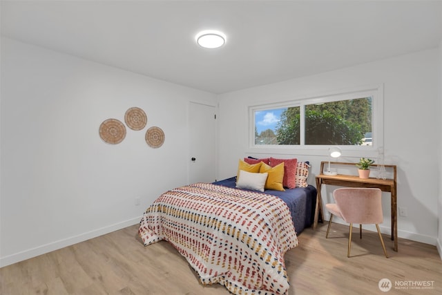 bedroom with light wood finished floors and baseboards