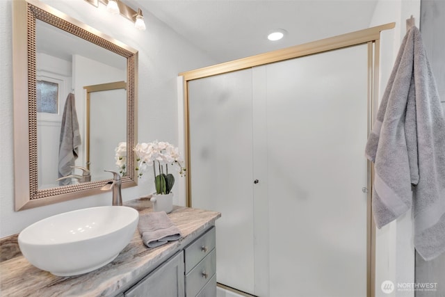 bathroom featuring a stall shower and vanity