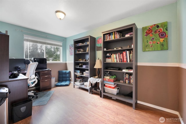 office space with light wood-type flooring and baseboards