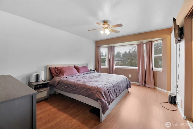 bedroom featuring light wood-style floors, ceiling fan, and baseboards