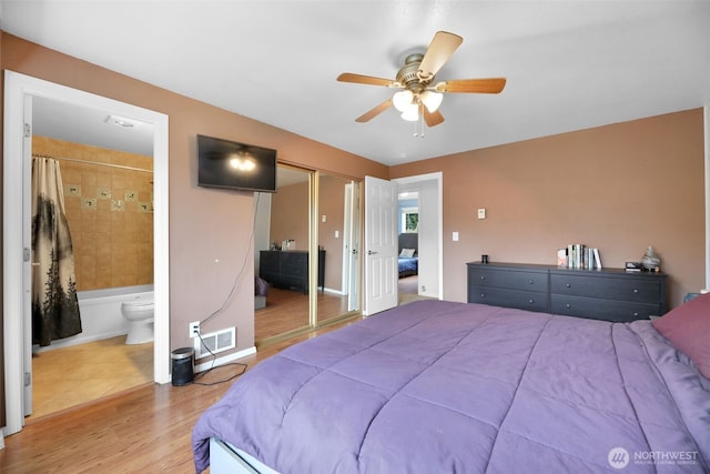 bedroom featuring visible vents, connected bathroom, ceiling fan, wood finished floors, and a closet