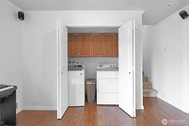 clothes washing area featuring cabinet space, ornamental molding, dark wood-style flooring, and independent washer and dryer