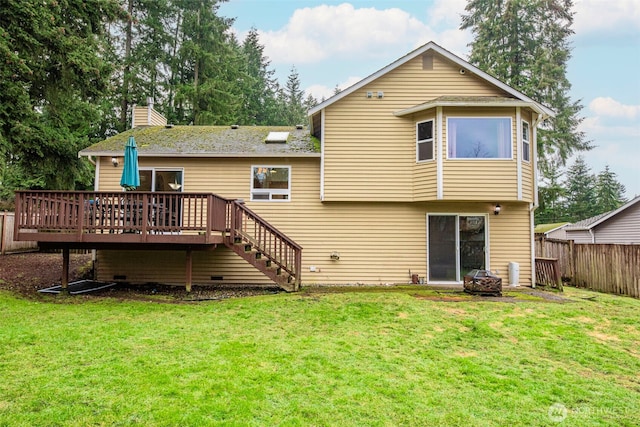 back of property with a deck, a yard, fence, and stairs