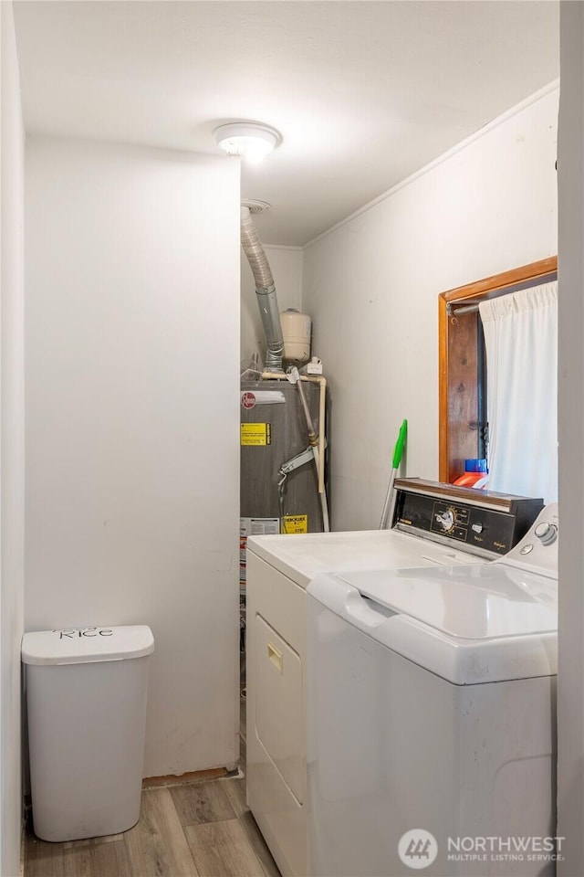 washroom featuring light wood-type flooring, washer and dryer, and water heater