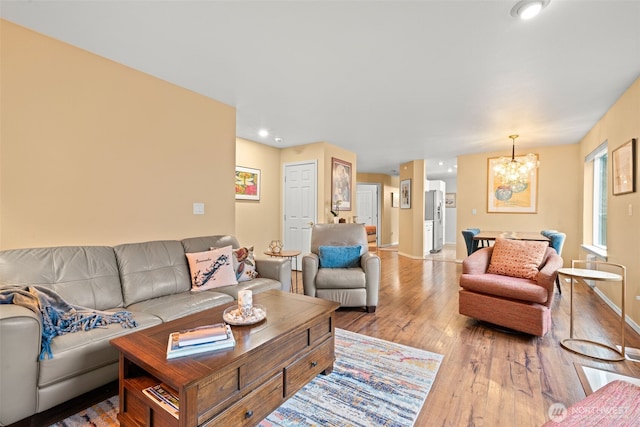 living room featuring light hardwood / wood-style floors and an inviting chandelier