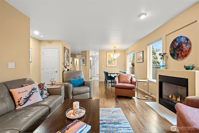 living room with an inviting chandelier and light hardwood / wood-style flooring