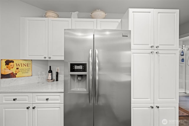 kitchen with white cabinetry and stainless steel refrigerator with ice dispenser