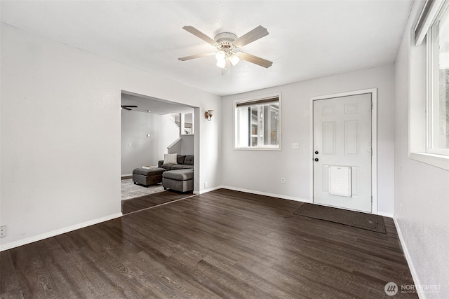 entryway with baseboards, ceiling fan, and dark wood-style floors