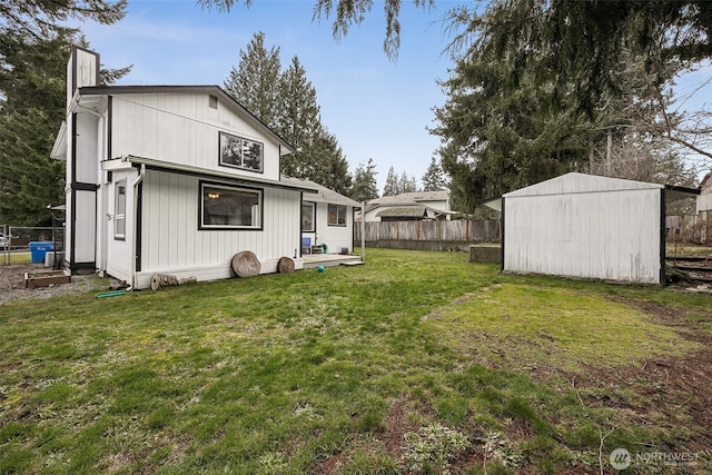 rear view of property with fence, an outdoor structure, a lawn, a chimney, and a shed