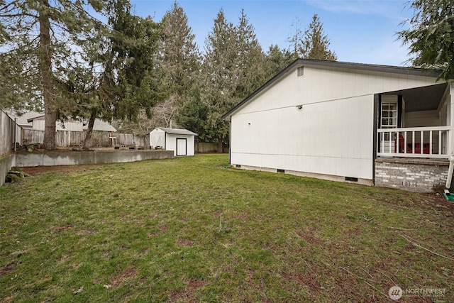 view of yard featuring a storage unit, an outdoor structure, and fence