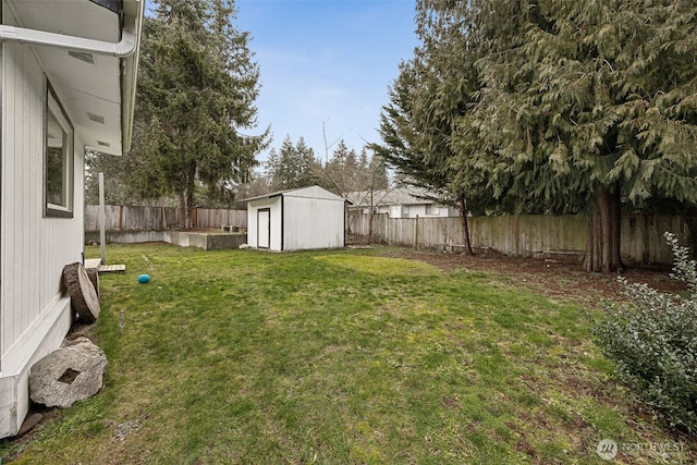 view of yard featuring a storage shed, an outdoor structure, and a fenced backyard