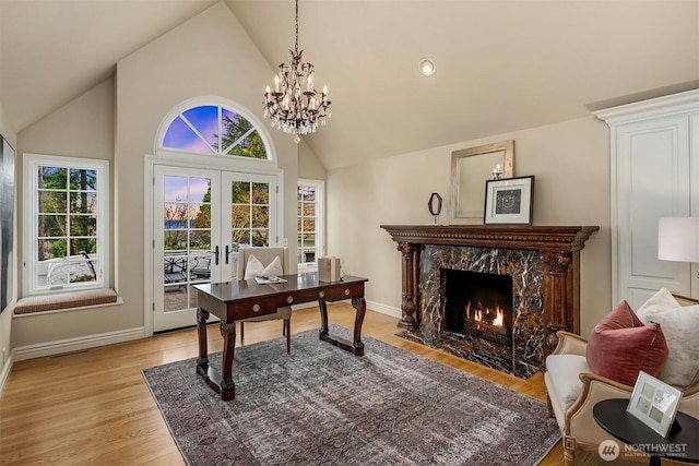 office area featuring high vaulted ceiling, a high end fireplace, baseboards, french doors, and light wood finished floors