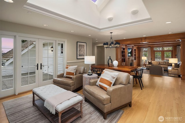 living area with light wood-style floors, recessed lighting, french doors, and an inviting chandelier