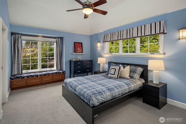 carpeted bedroom featuring vaulted ceiling, multiple windows, visible vents, and baseboards