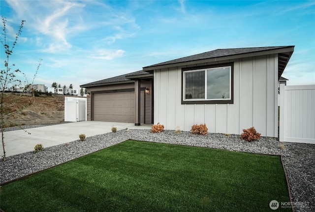 view of front of property with board and batten siding, concrete driveway, fence, and a garage