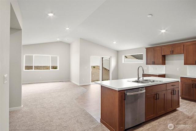 kitchen with light countertops, stainless steel dishwasher, vaulted ceiling, a sink, and an island with sink