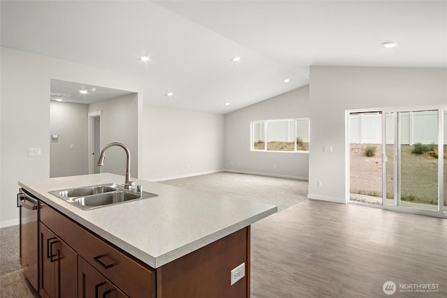 kitchen with dishwasher, open floor plan, a sink, and light countertops