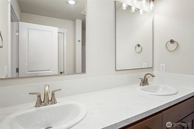 full bathroom with double vanity and a sink