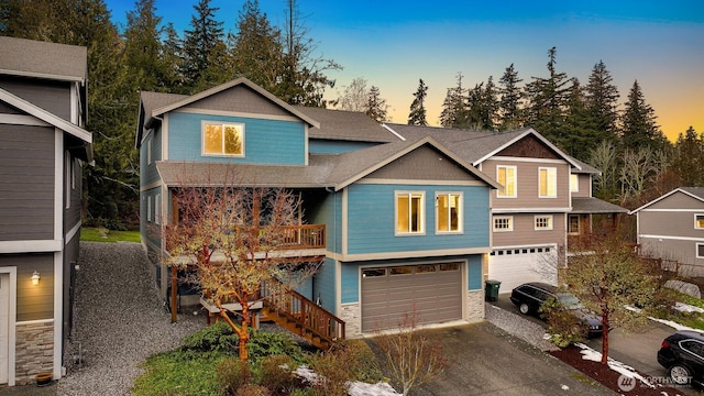 view of front of home with a garage, concrete driveway, stairway, and stone siding