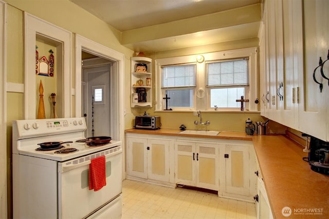 kitchen with electric stove, light floors, a sink, and light countertops