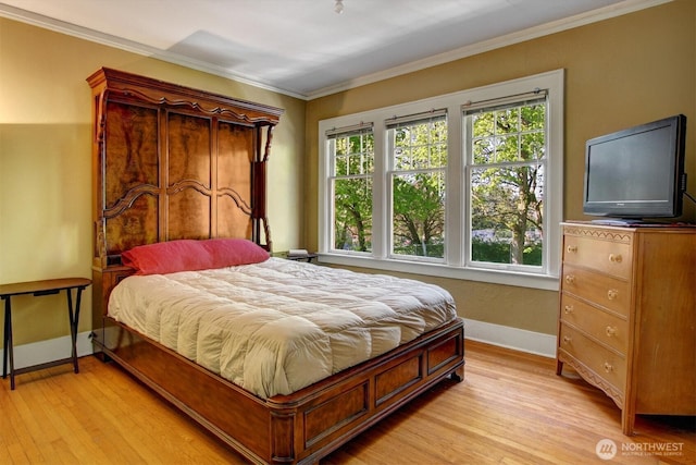 bedroom featuring light wood-style flooring, baseboards, and crown molding