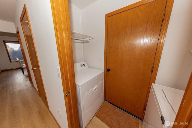 clothes washing area featuring light hardwood / wood-style floors and separate washer and dryer