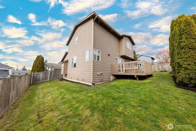 back of house with a deck and a lawn