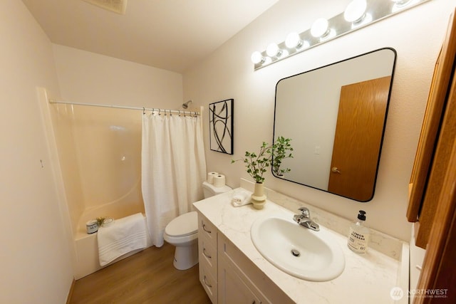 full bathroom with hardwood / wood-style flooring, toilet, shower / bathtub combination with curtain, and vanity