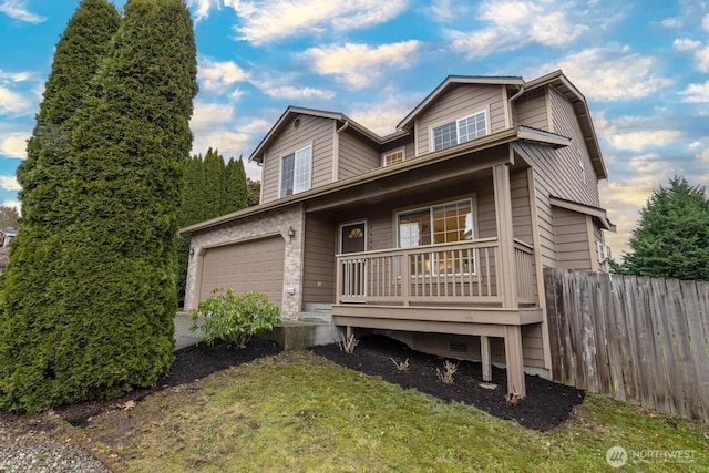 view of front of home featuring a garage, a front yard, and a porch