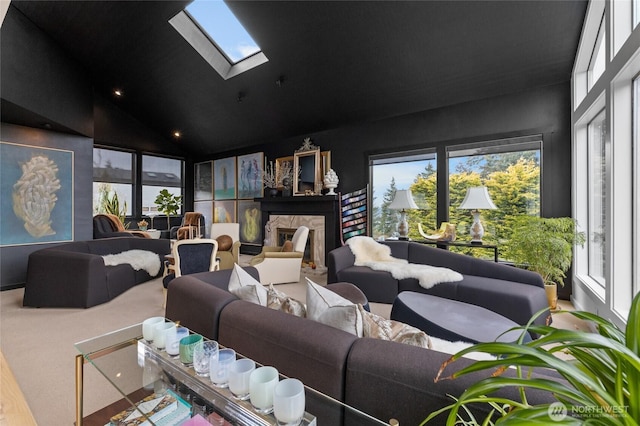 carpeted home theater featuring a fireplace, a skylight, and high vaulted ceiling