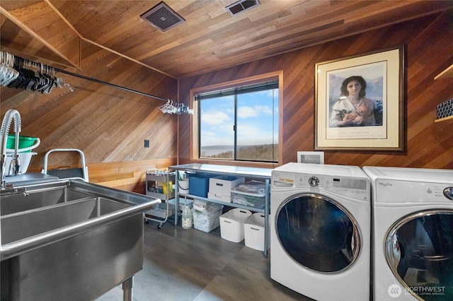 laundry area featuring wooden ceiling, sink, washer and dryer, and wooden walls