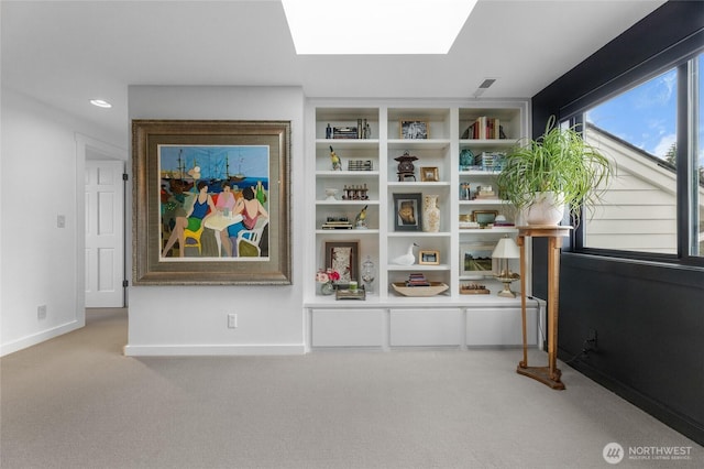 sitting room featuring light carpet and a skylight